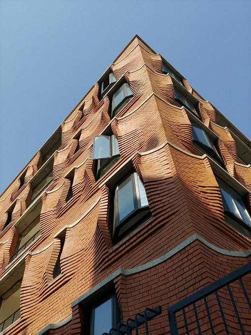 berombak fasad apartemen ini terbuat dari batu bata