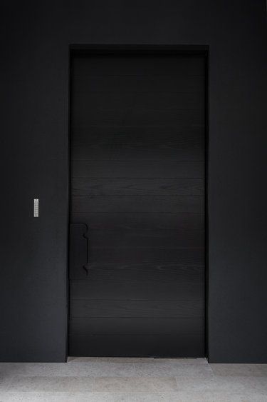pintu solid minimalis dari kayu yang dicat hitam